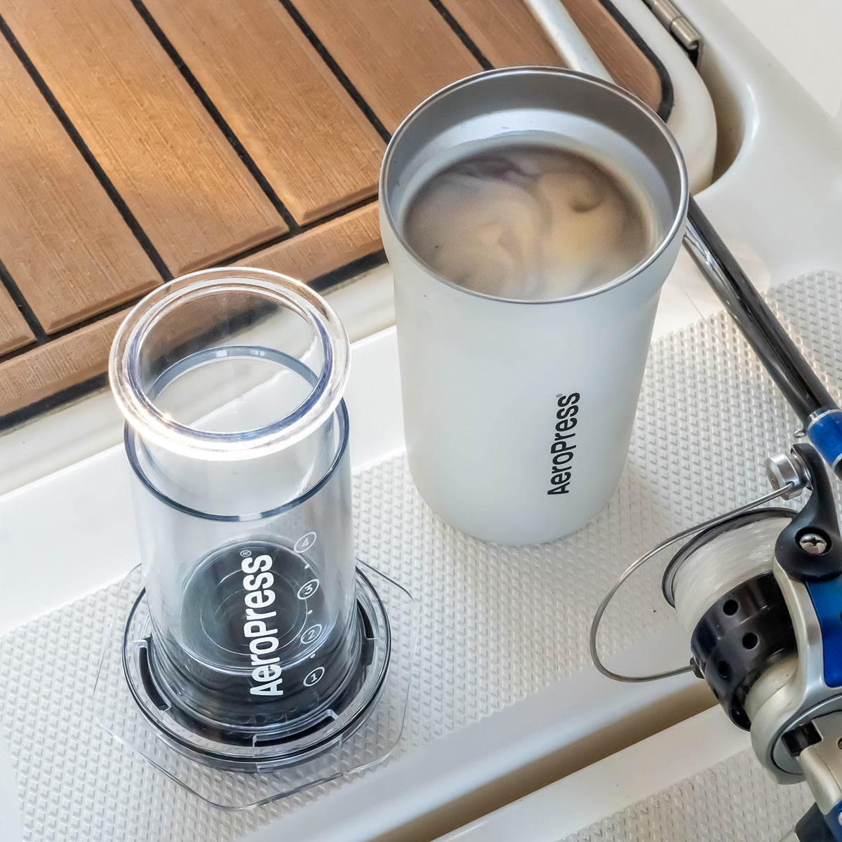 Aeropress coffee maker and a cup of coffee on a boat deck.
