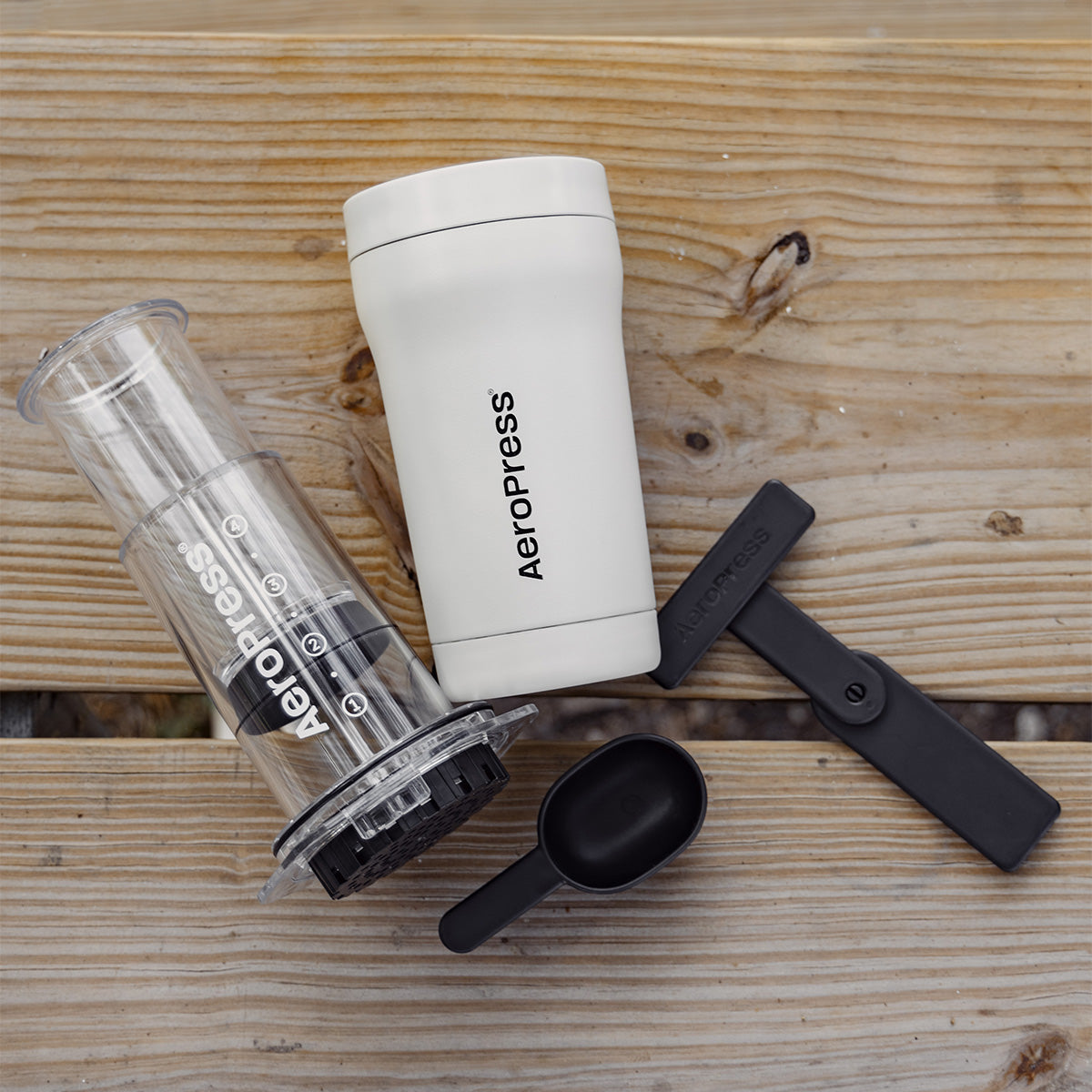 Aeropress coffee brewing kit on a wooden surface